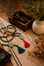 Load image into Gallery viewer, Handcrafted Mala meditation beads with deep green stones, sandalwood beads and red tassel pendant — designed for mindfulness, prayer and spiritual grounding
